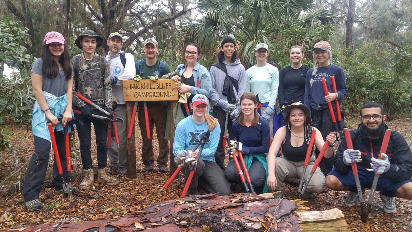 Diverse group of college students enjoying outdoor recreation at a sustainable campground, promoting social inclusion and wellness in campus life.