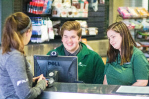 Welcome desk employee and manager at UAB talk to a member