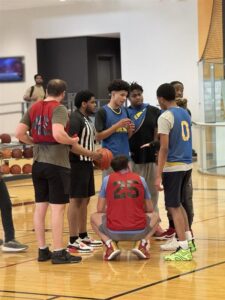 Student staff trained with AI on conflict resolution explain rules to opposing teams.