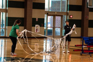Marshall University recreation leaders solving an operational challenge by untangling a volleyball net together