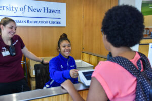 Manager oversees front desk operations as a guest checks in at the University of New Haven recreation center