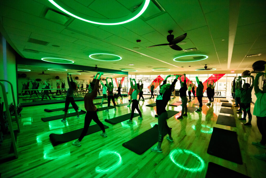Yoga studio with green mood lighting supporting mind-body fitness and student wellbeing.